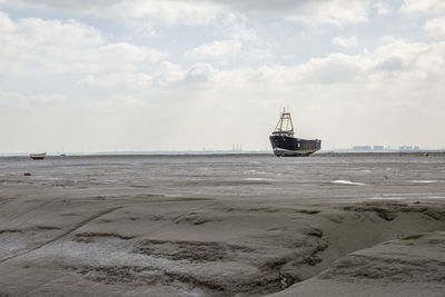 Fisherman boats stuck on the beach in low tide period in leigh-on-sea, uk.