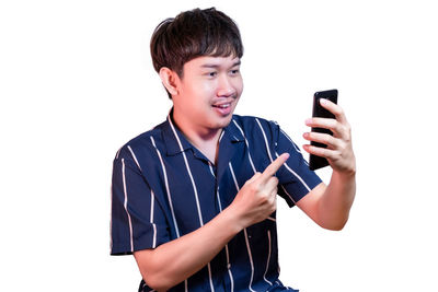 Low angle view of man using mobile phone against white background