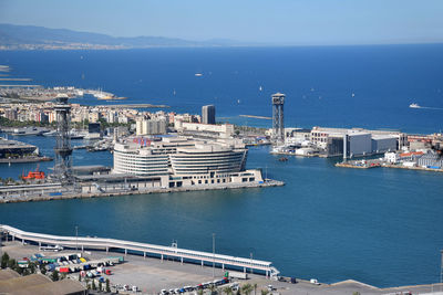 High angle view of harbor against buildings in city. clear sky at barcelona's port