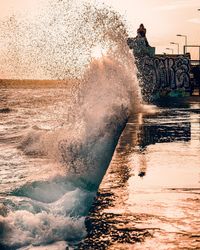 Man splashing water in sea against sky