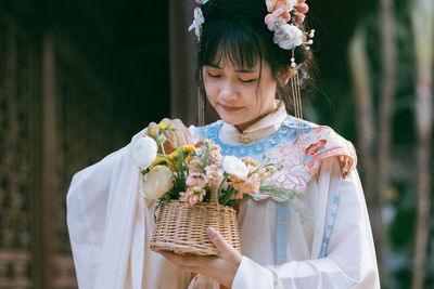 Portrait of woman holding white flower