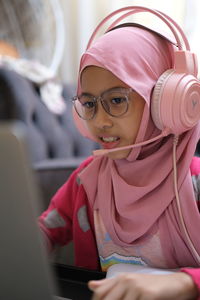 Close-up of a girl with spectackles having online class