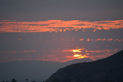 Low angle view of silhouette mountains against romantic sky