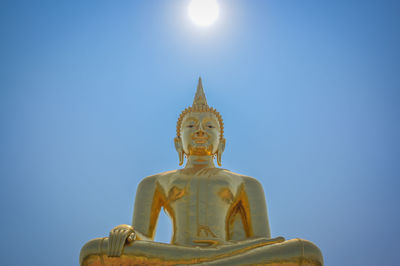 Golden buddha and the sun at noon