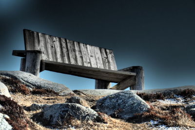 Old wooden bench against clear sky