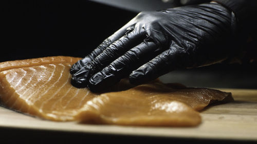 Cropped hand of person preparing food on table