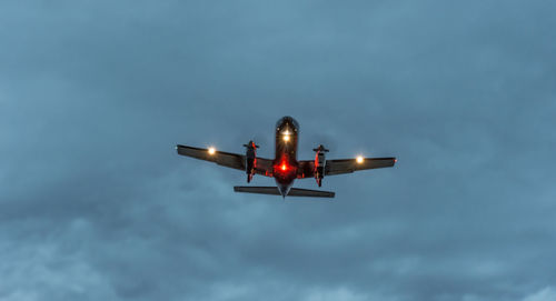 Low angle view of illuminated airplane against sky
