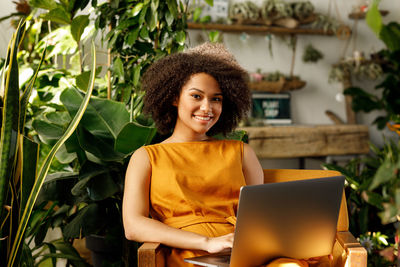 Portrait of smiling young woman using mobile phone