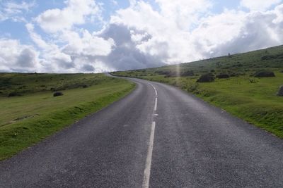 Empty road passing through field