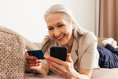 Young woman using mobile phone at home