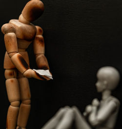 Close-up of wooden figurines against black background