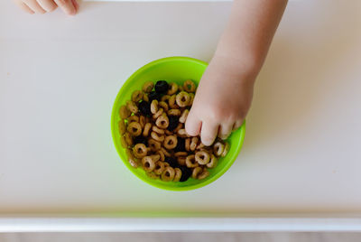 Close-up of hand holding bowl of table