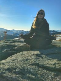 Woman sitting on snow covered landscape