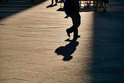 Low section of man walking on road