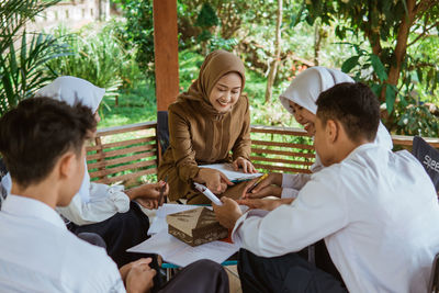 Side view of friends using digital tablet