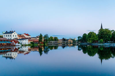 Reflection of houses in lake against sky