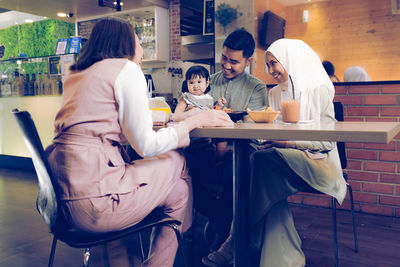 Rear view of people sitting at table