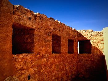 Low angle view of old ruin against clear blue sky