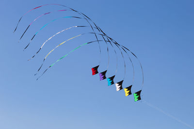 Low angle view of airshow against clear blue sky