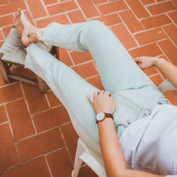 Low section of young woman sitting on chair