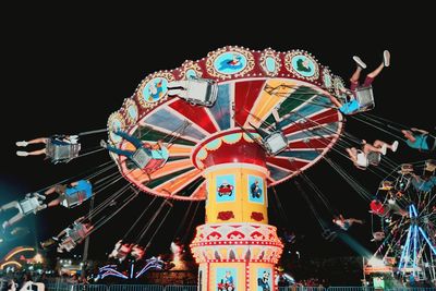 Low angle view of illuminated ferris wheel against sky at night