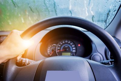 Close-up of human hand on car windshield