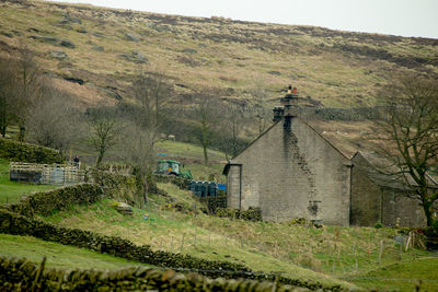 Scenic view of field by buildings against sky