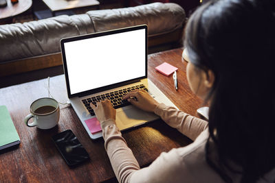 Businesswoman working on laptop at desk in loft office