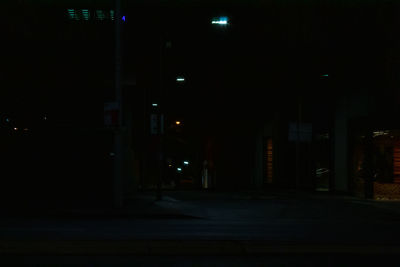 Illuminated street amidst buildings in city at night