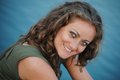 Portrait of a smiling young woman against blue sky