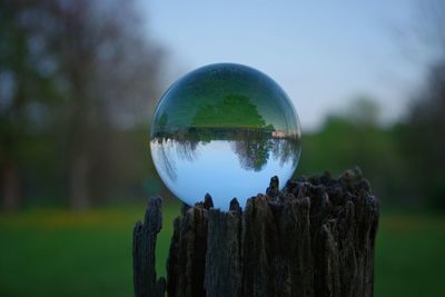 Close-up of crystal ball on fence post