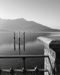 Wooden posts in sea against clear sky