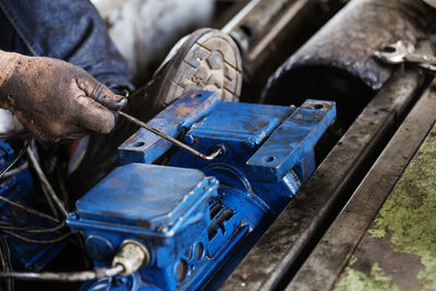 Low section of man repairing machinery