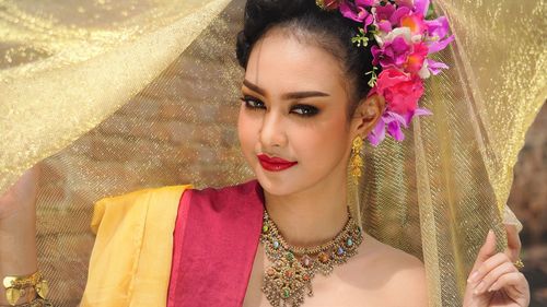 Portrait of smiling young woman in traditional clothing standing outdoors