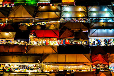 Group of people in illuminated market at night