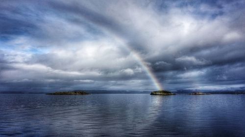 Scenic view of rainbow over sea against sky