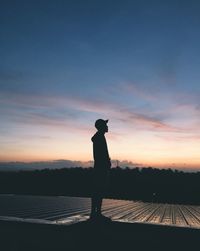 Silhouette man standing against sky during sunset