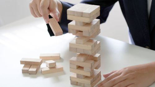 Cropped image of hand holding stack of table