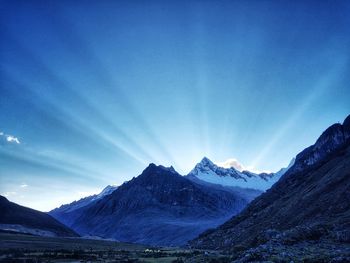 Scenic view of snowcapped mountains against blue sky