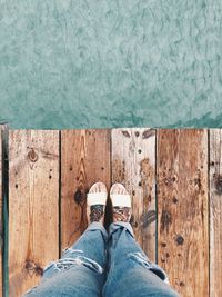 Low section of woman standing on pier over sea