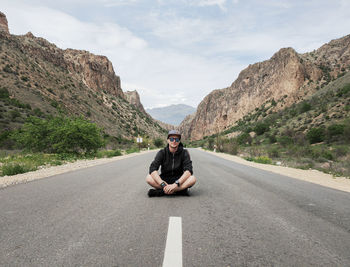 Rear view of man sitting on road