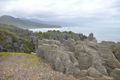 Scenic view of sea and mountains against sky