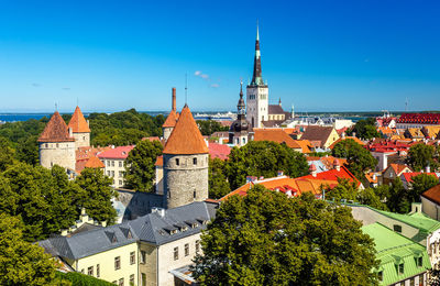 Panoramic view of buildings and trees against blue sky