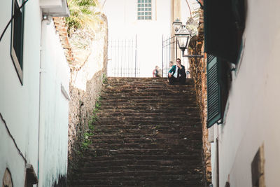 Low angle view of man with hand on chin sitting on steps