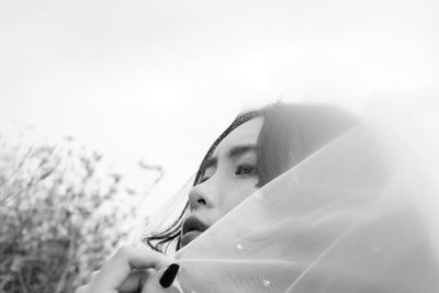 Close-up of thoughtful bride against clear sky