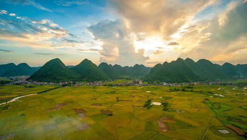 Scenic view of field against cloudy sky