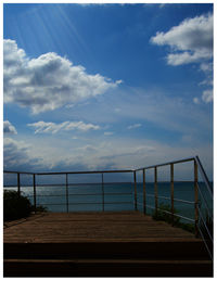 Railing by sea against sky