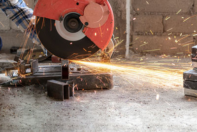 Cropped hand of worker using grinder in workshop