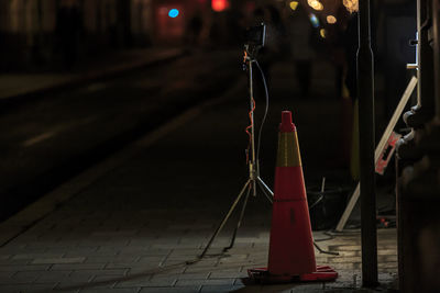 Close-up of illuminated lighting equipment on footpath at night