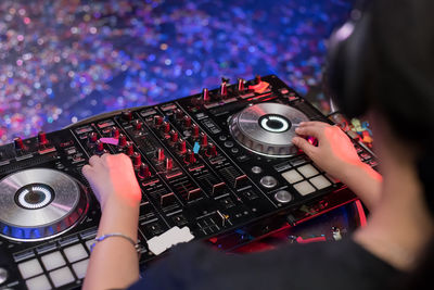 Close-up of woman playing music on audio equipment in nightclub